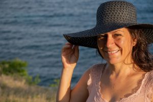 Photo de Christine qui sourit avec en fond la mer