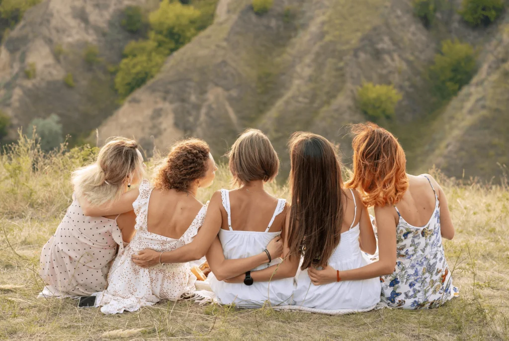 groupe de femmes assissent de dos se tenant par la taille